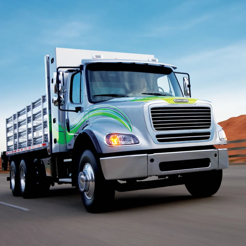Dynamic shot of a Freightliner M2 112 Natural Gas truck with vibrant green accents transporting cargo on a highway